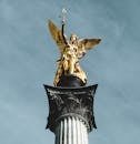 Golden angel sculpture atop Victory Column with a clear sky in Munich.